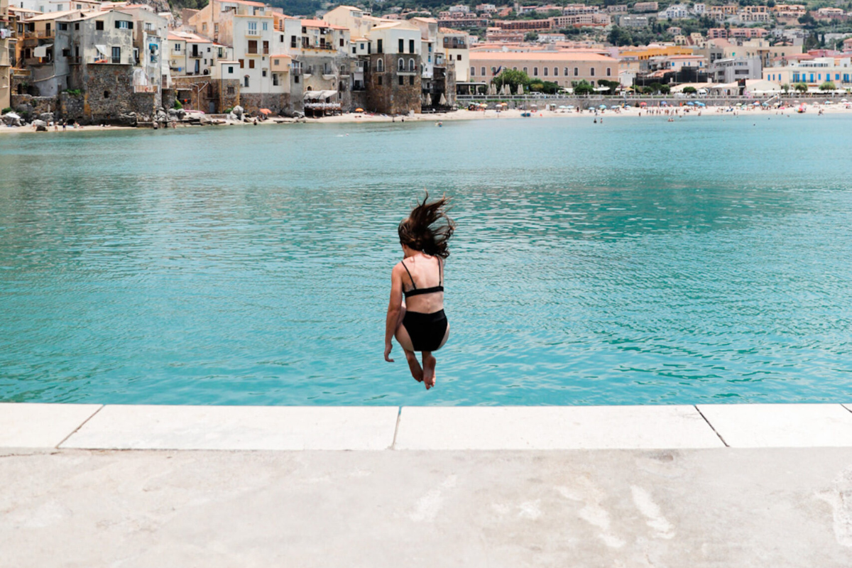 Image of a woman jumping into the sea.
