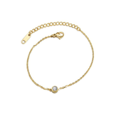 Gold bracelet with a small clear round gemstone on a white background