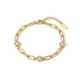 Gold chain bracelet with three diamond-like stones on a white background