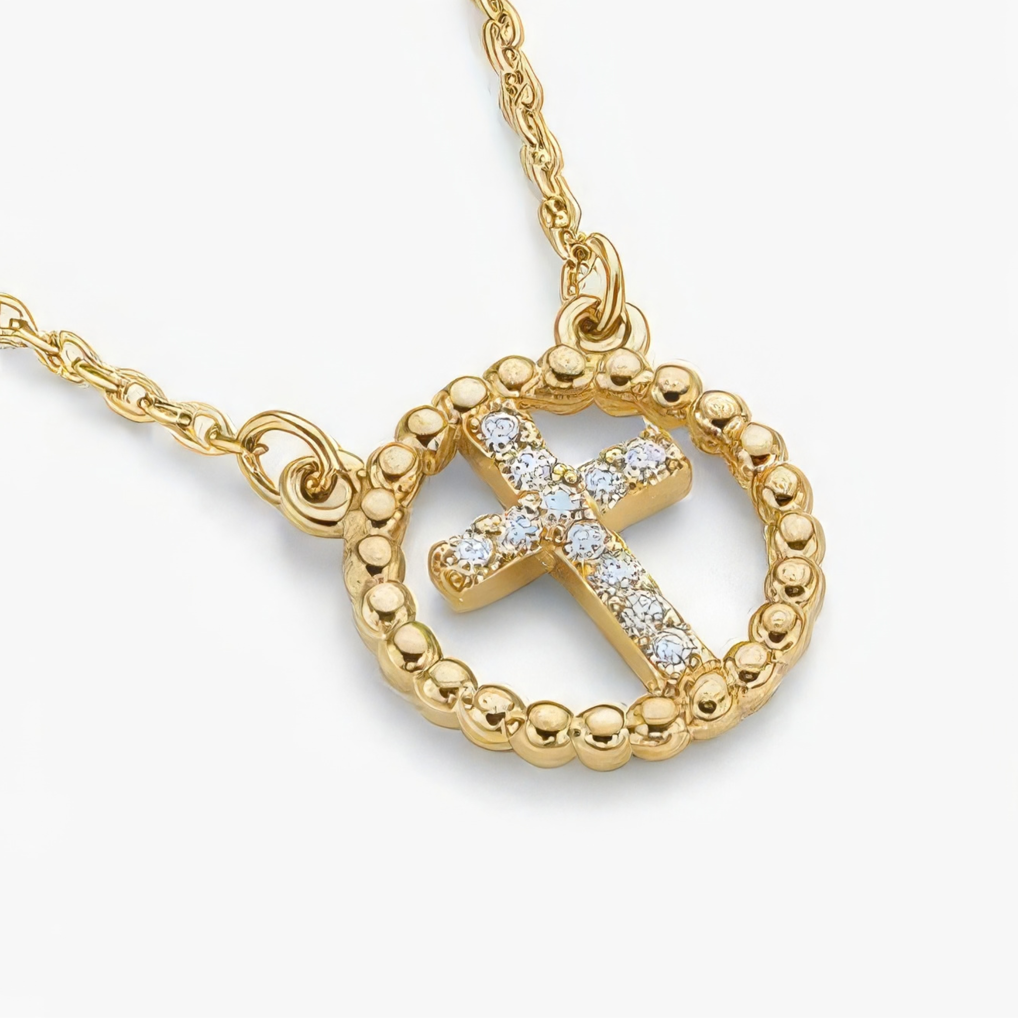 Gold cross necklace with rhinestones on a white background