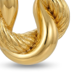 Closeup of a gold hoop earring on a white background