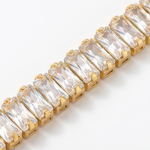 Close up of a gold bracelet with clear baguette gemstones on a white background