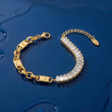 Gold bracelet with clear baguette crystals accents on a wet blue surface