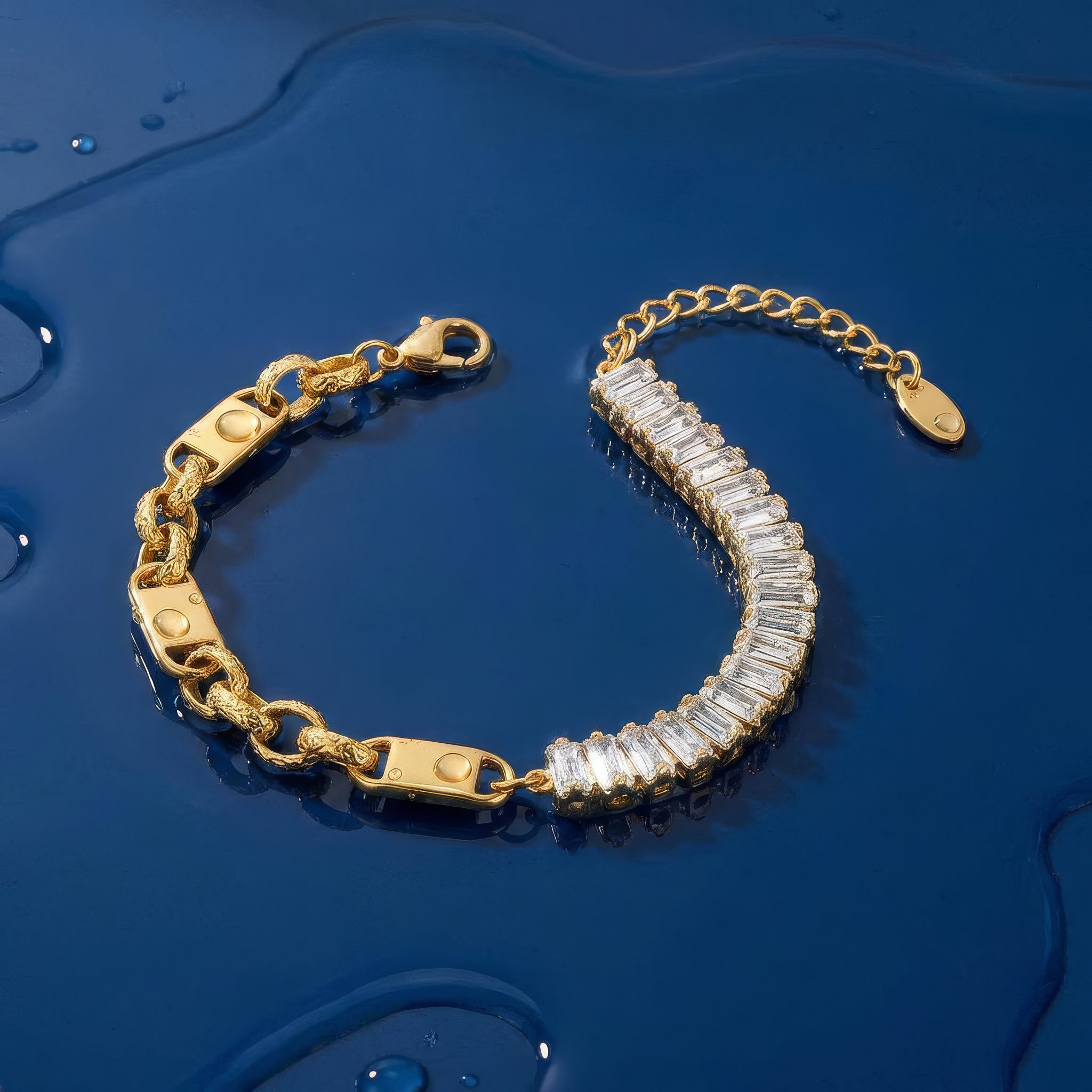 Gold bracelet with clear baguette crystals accents on a wet blue surface