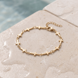 Mini Crosses Bracelet on the ledge of a pool