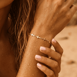 Mini Crosses Bracelet on the wrist of a woman with wet skin and a neutral background