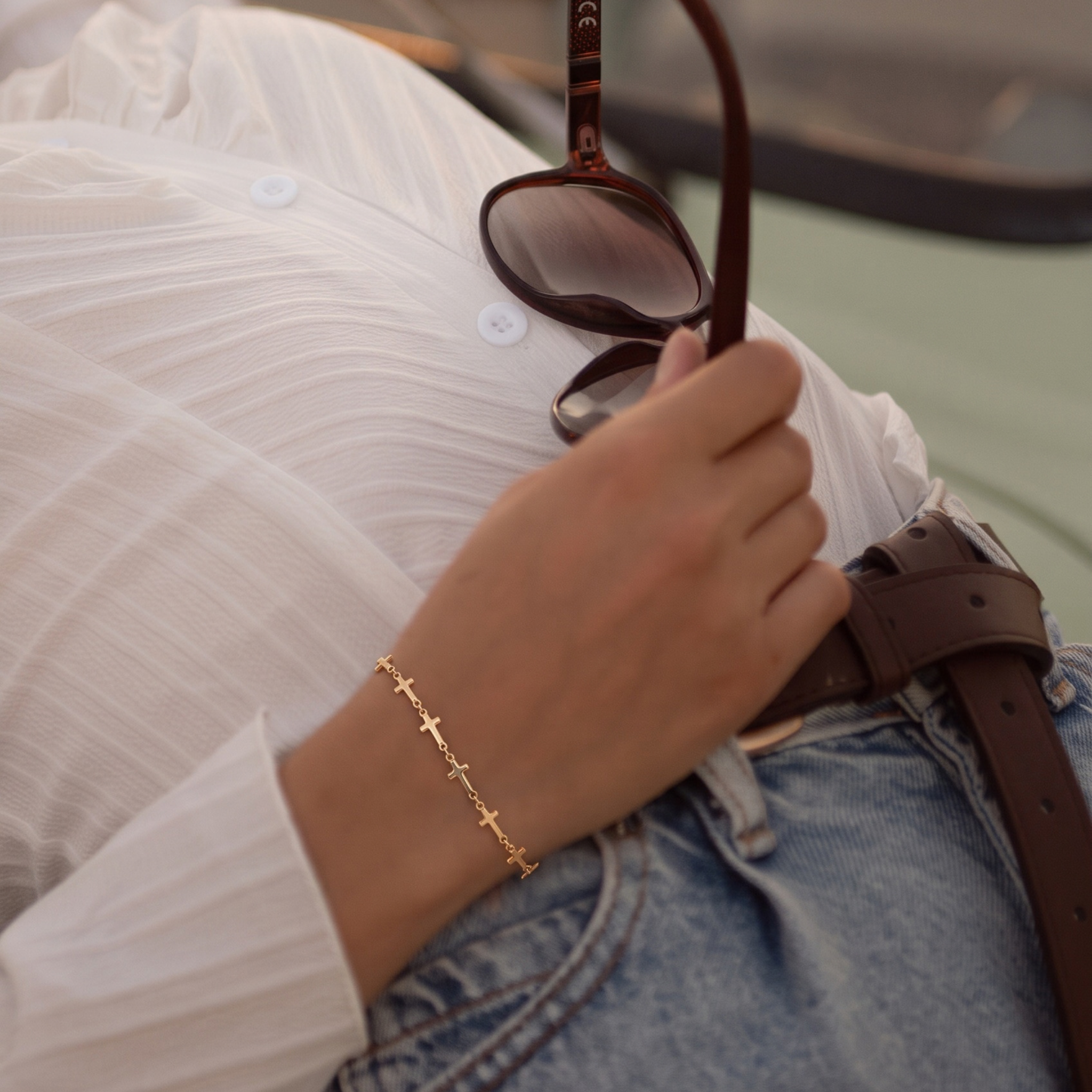 Mini Crosses Bracelet on a wrist of a woman who is leaning back