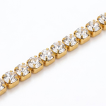 Gold bracelet with clear gemstones on a white background