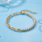 Gold bracelet with clear stones on a light blue glossy wet surface