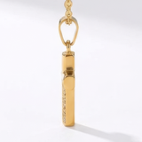 Side view of a gold necklace with a cross pendant on a white background