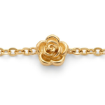 Close up of stationary gold rosebud design on a gold bracelet on a white background