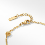 Close up of clasp of gold bracelet with stationary gold rosebud designs spaced out on the chain on a white background