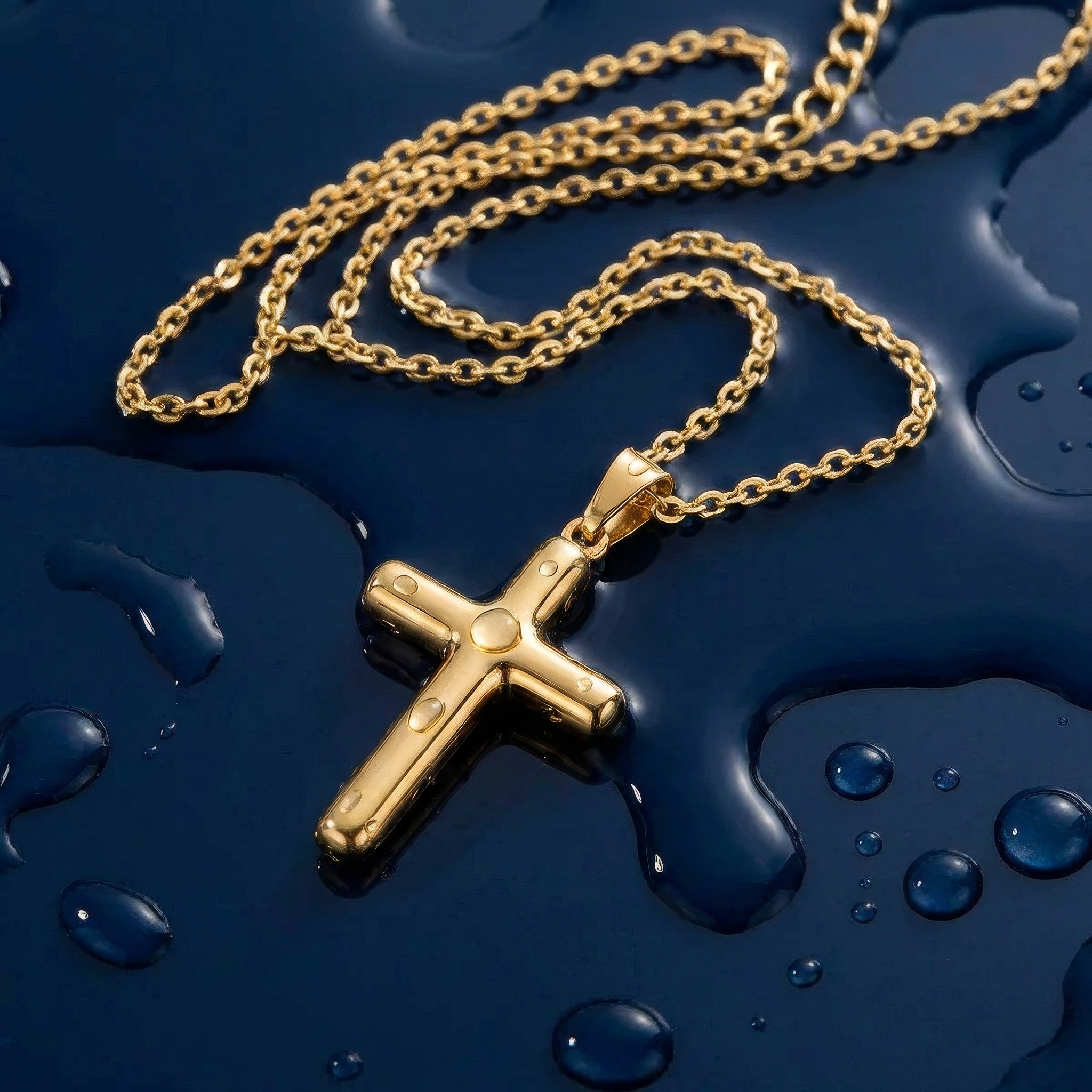 Gold cross necklace on a wet navy blue surface.