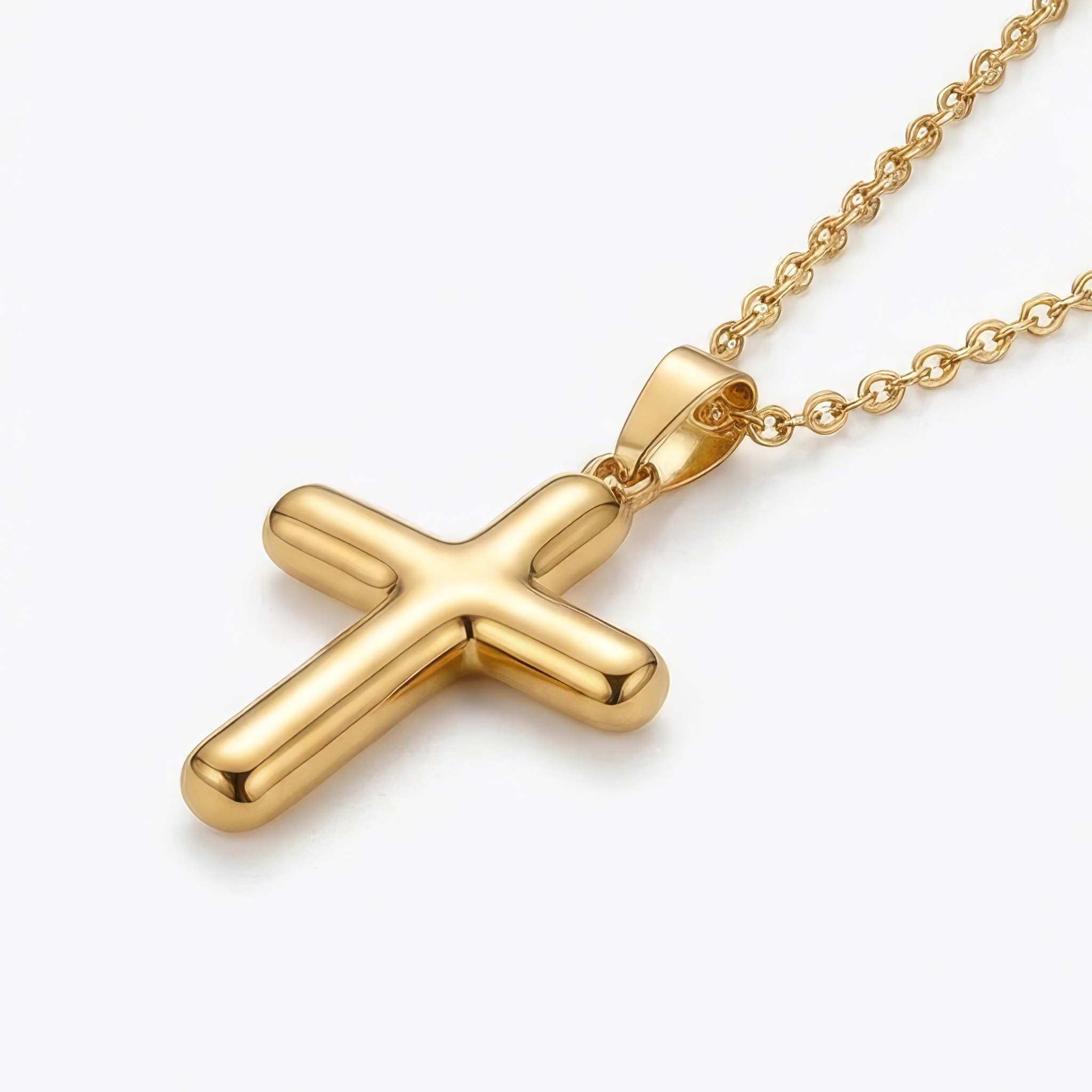 Gold cross necklace lying flat on a white background.