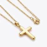 Gold cross necklace on a white background