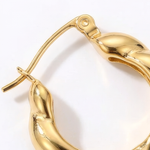 Close up of a gold hoop earring on a white background